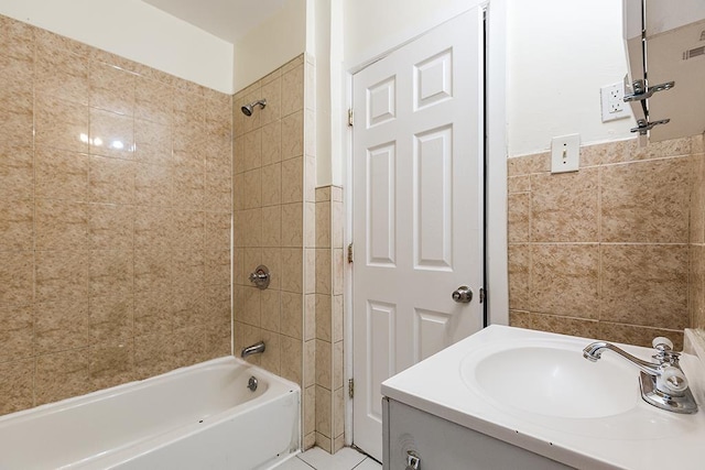 bathroom with tile patterned flooring, vanity, shower / bath combination, and tile walls