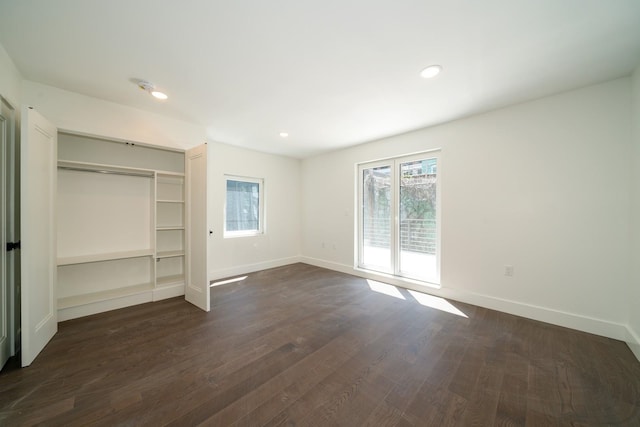 unfurnished bedroom with dark wood-type flooring, access to exterior, and a closet