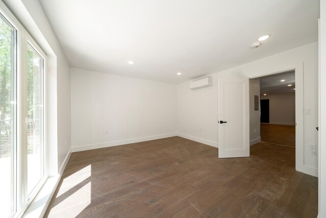 spare room with dark hardwood / wood-style flooring and a wall mounted air conditioner