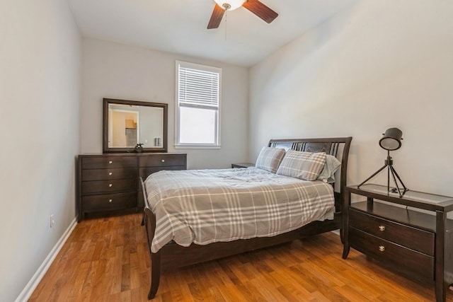 bedroom featuring light wood-style flooring, baseboards, and ceiling fan