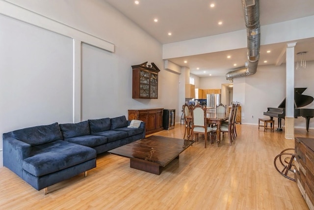 living room with recessed lighting, baseboards, and light wood finished floors