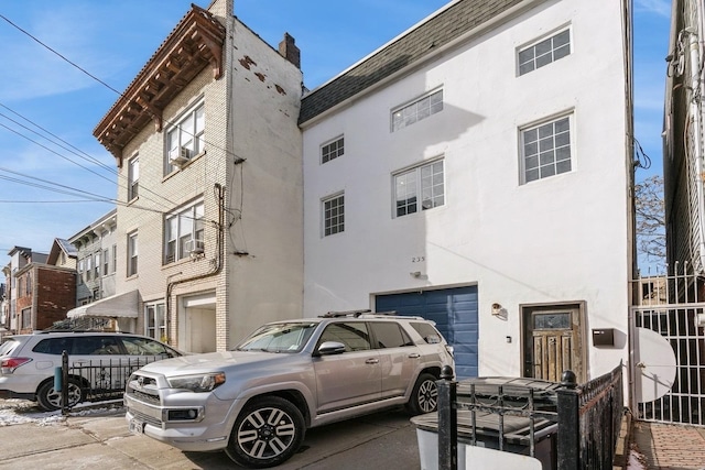 view of building exterior with driveway and an attached garage