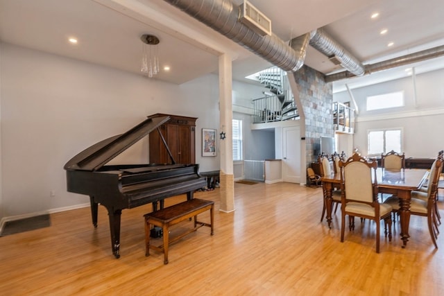 dining area with baseboards, light wood-type flooring, and a healthy amount of sunlight