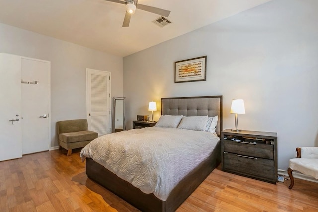 bedroom with light wood-type flooring, ceiling fan, visible vents, and a closet