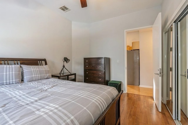 bedroom featuring light wood-style floors, visible vents, and ceiling fan