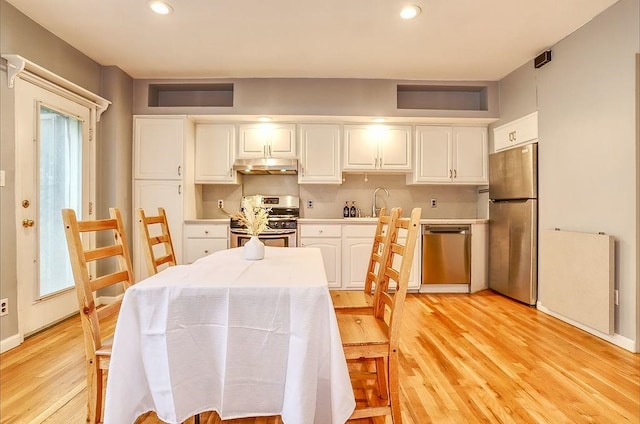 940 Bloomfield St # 1, Hoboken, NJ 07030 - kitchen featuring appliances with stainless steel finishes, under cabinet range hood, white cabinetry, light wood-type flooring, and recessed lighting