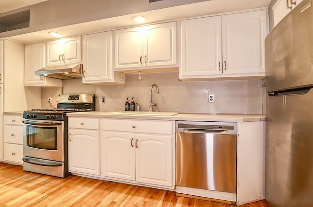 940 Bloomfield St # 1, Hoboken, NJ 07030 - kitchen featuring stainless steel appliances, under cabinet range hood, light countertops, white cabinetry, and light wood-type flooring
