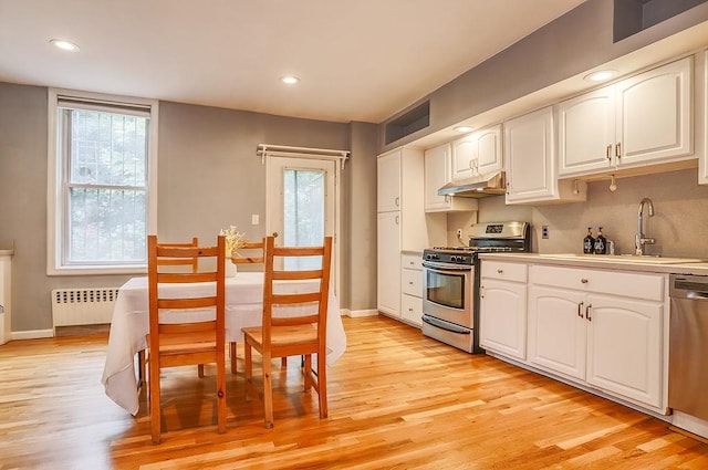 940 Bloomfield St # 1, Hoboken, NJ 07030 - kitchen with appliances with stainless steel finishes, radiator, under cabinet range hood, light wood-style flooring, and recessed lighting