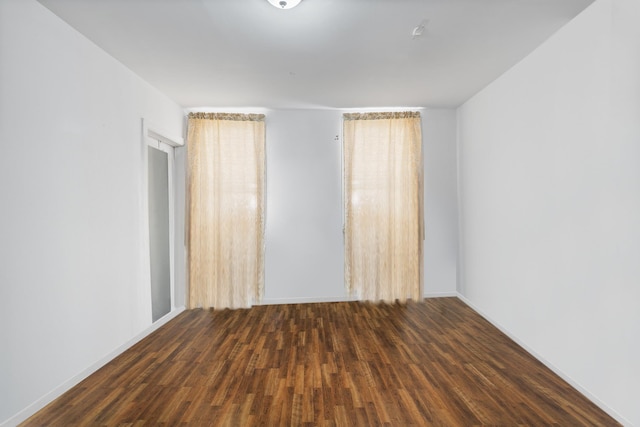 empty room with dark hardwood / wood-style flooring