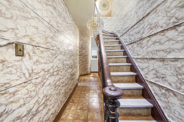 staircase featuring a chandelier