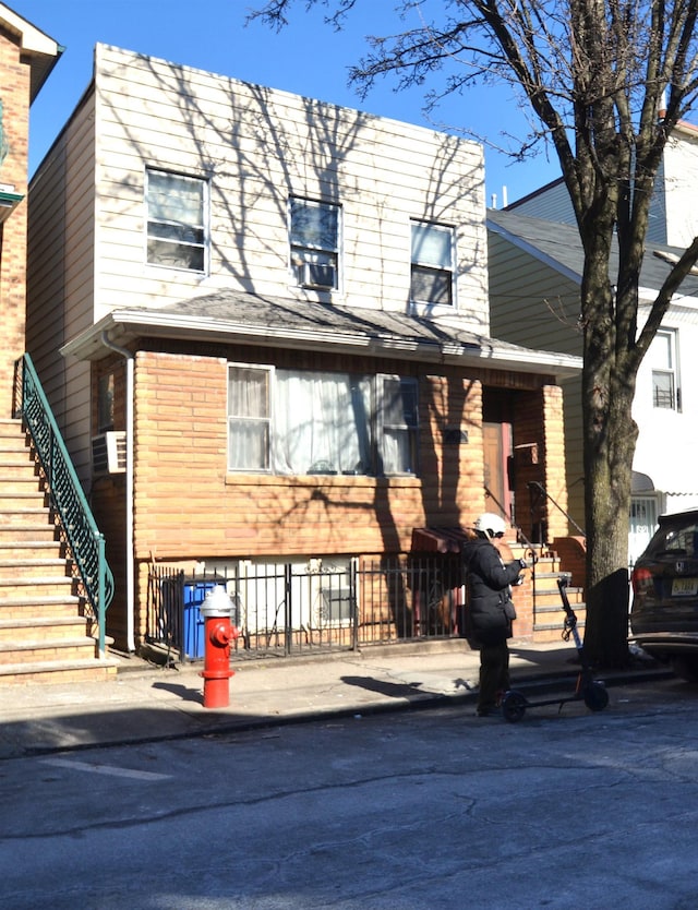 view of front facade featuring fence and stairway