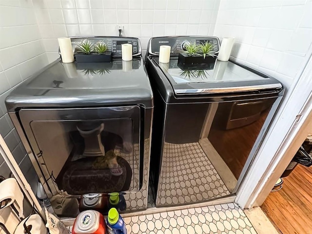 laundry area featuring laundry area, washer / dryer, and tile walls