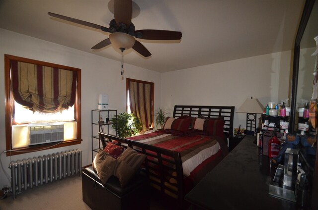 bedroom featuring carpet floors, cooling unit, radiator, and a ceiling fan