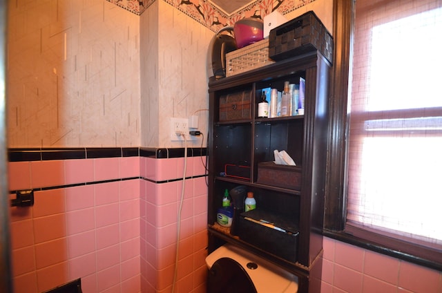 bathroom with plenty of natural light and tile walls