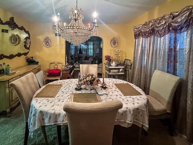 carpeted dining space with a chandelier