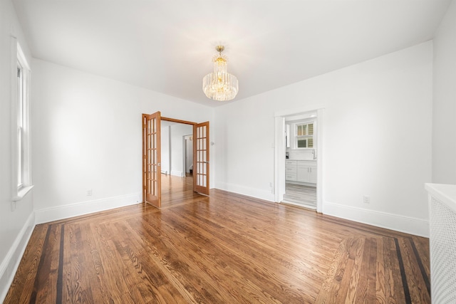 1007 88th St, North Bergen, NJ 07047 - empty room with a chandelier, wood finished floors, and french doors