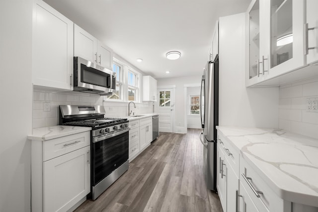 1007 88th St, North Bergen, NJ 07047 - kitchen with stainless steel appliances, white cabinets, decorative backsplash, and recessed lighting