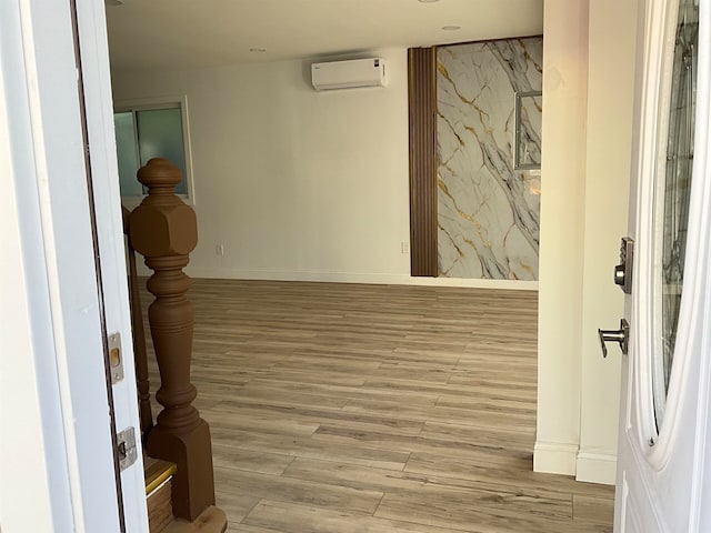 corridor with a wall mounted air conditioner and light hardwood / wood-style floors