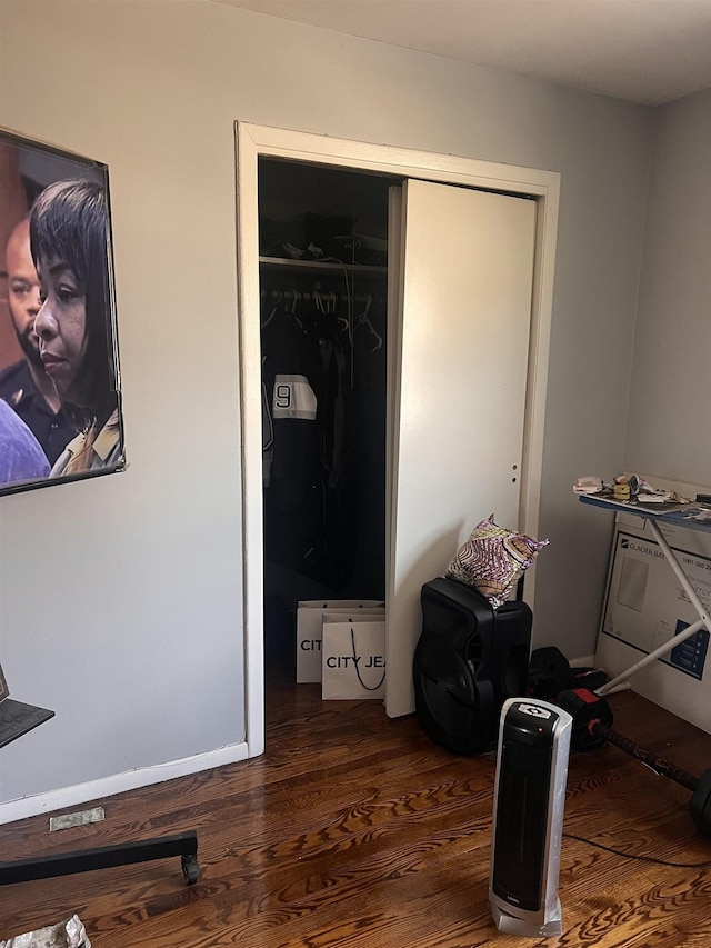 bedroom with dark hardwood / wood-style floors and a closet