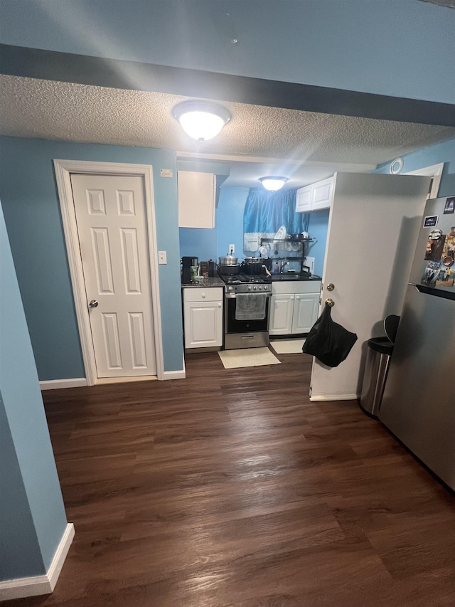 kitchen featuring dark wood-type flooring, white cabinetry, stainless steel appliances, and sink