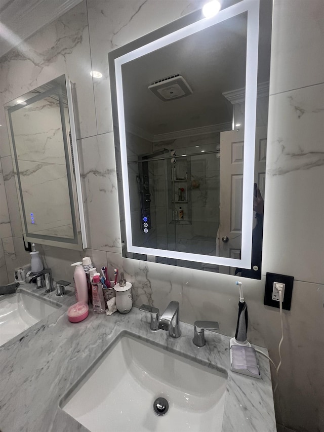 bathroom with an enclosed shower, vanity, and ornamental molding