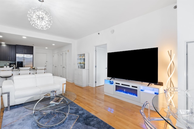 living room with baseboards, light wood-style flooring, and recessed lighting