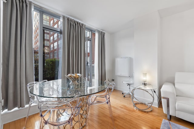 dining space with baseboards and light wood-style floors