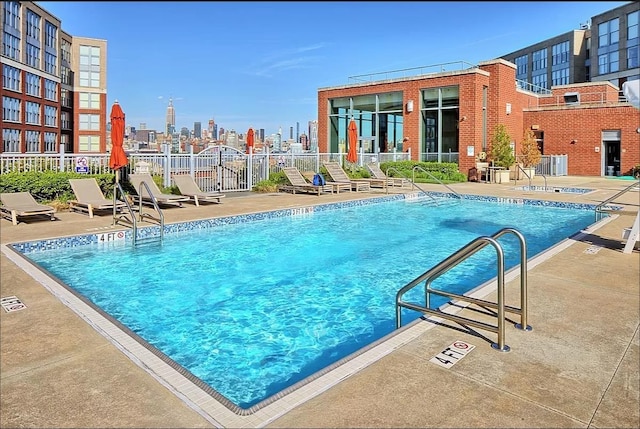 pool with central AC unit, fence, and a patio