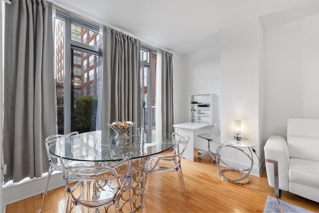 dining area with hardwood / wood-style flooring and baseboards