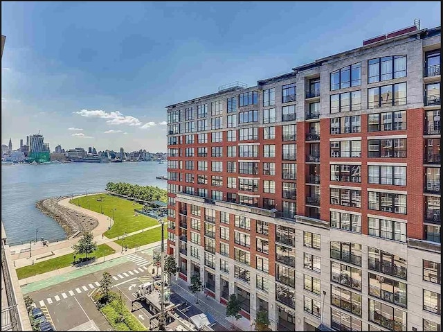 view of building exterior featuring a water view and a city view