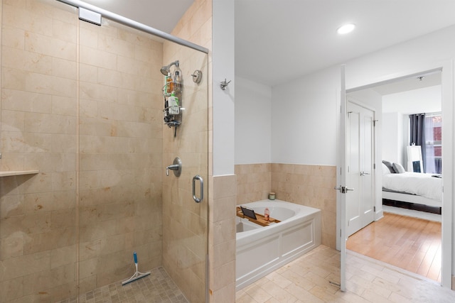 bathroom with ensuite bath, a garden tub, recessed lighting, and a stall shower
