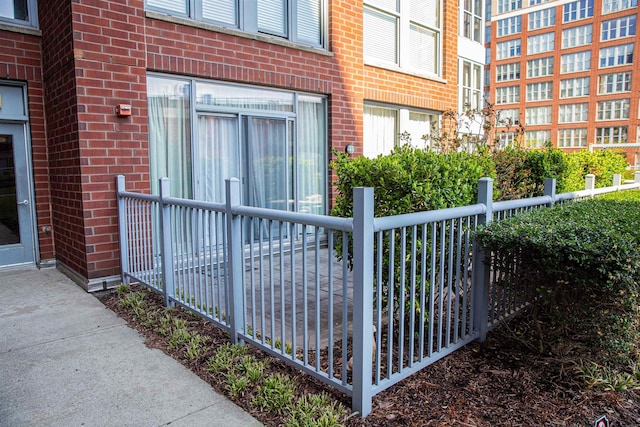 exterior space featuring brick siding and fence