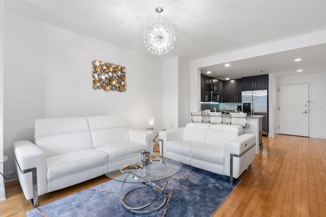 living room featuring light wood finished floors, recessed lighting, and an inviting chandelier