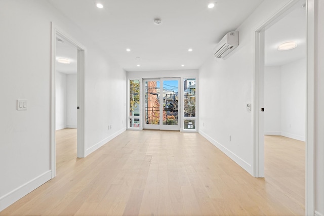 corridor featuring an AC wall unit and light hardwood / wood-style flooring