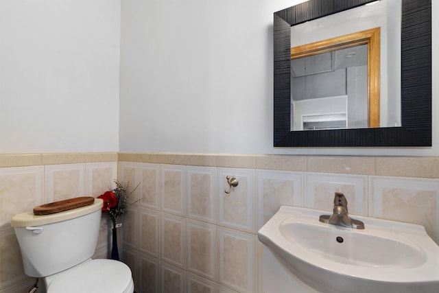 bathroom featuring tile walls, a sink, and toilet