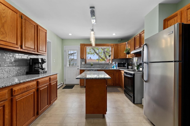 kitchen featuring appliances with stainless steel finishes, backsplash, light stone countertops, brown cabinetry, and recessed lighting
