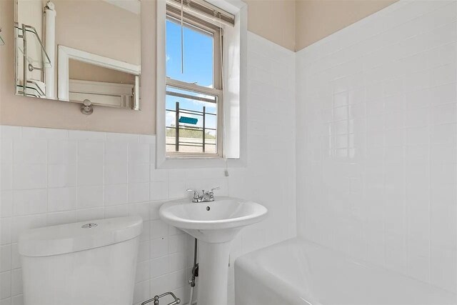 16 Belvidere Ave Unit 3F, Jersey City, NJ 07304 - full bathroom with plenty of natural light, toilet, tile walls,  shower combination, and a sink