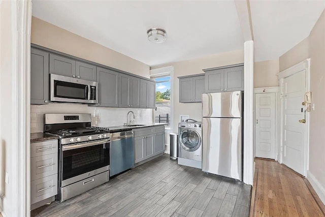 16 Belvidere Ave Unit 3F, Jersey City, NJ 07304 - kitchen featuring stainless steel appliances, washer / dryer, gray cabinets, a sink, and tasteful backsplash