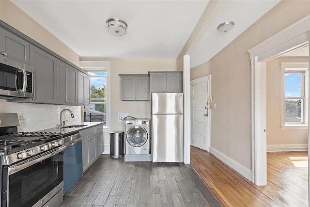 16 Belvidere Ave Unit 3F, Jersey City, NJ 07304 - kitchen with appliances with stainless steel finishes, washer / dryer, a sink, gray cabinets, and dark wood-style floors
