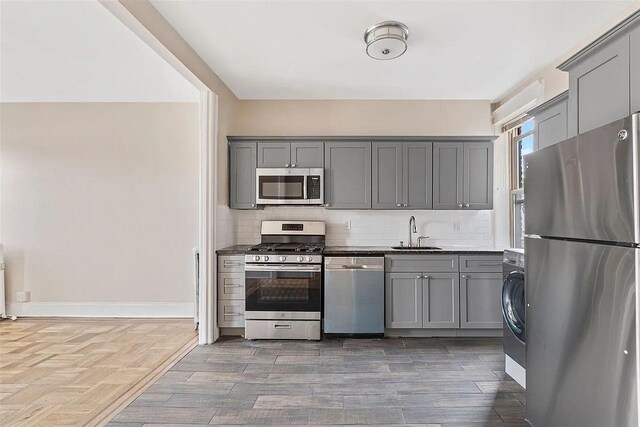 16 Belvidere Ave Unit 3F, Jersey City, NJ 07304 - kitchen featuring stainless steel appliances, gray cabinets, a sink, and backsplash