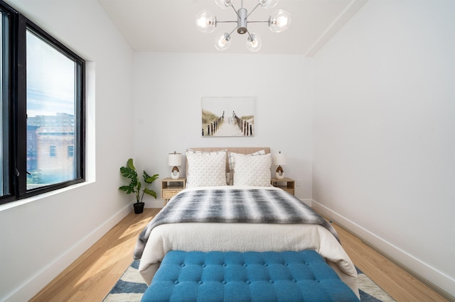 70 Gardner Ave Unit 2, Jersey City, NJ 07304 - bedroom with a chandelier, light wood-style floors, and baseboards