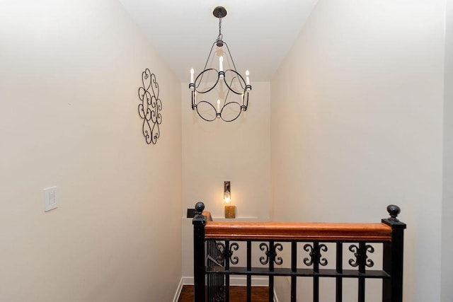 stairway featuring baseboards and an inviting chandelier
