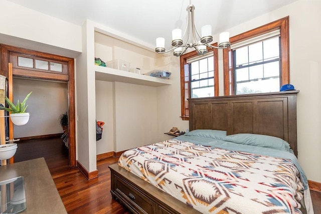 bedroom with baseboards, an inviting chandelier, dark wood finished floors, and a closet