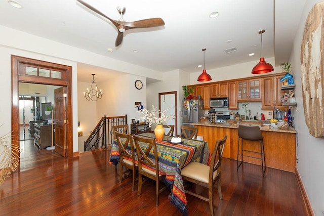 dining area featuring dark wood-style flooring, recessed lighting, ceiling fan with notable chandelier, and visible vents