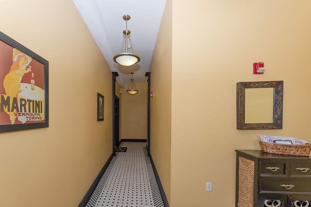 hallway with baseboards and light floors