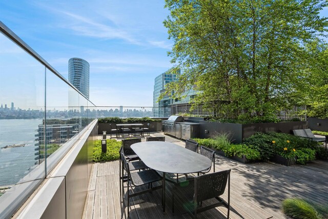 2 Shore Ln Unit 410, Jersey City, NJ 07310 - wooden deck with outdoor dining space, a city view, area for grilling, and a water view