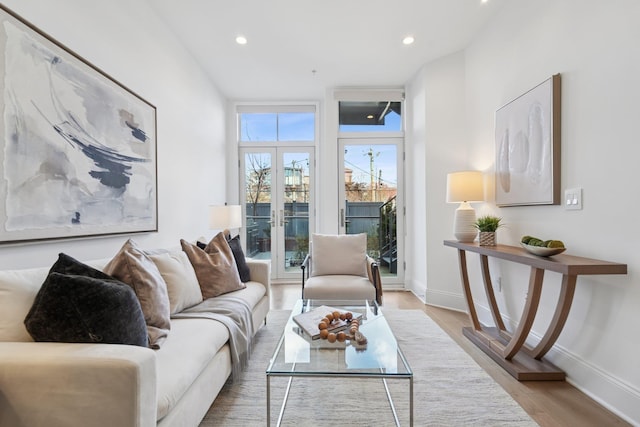 living area with recessed lighting, french doors, baseboards, and wood finished floors