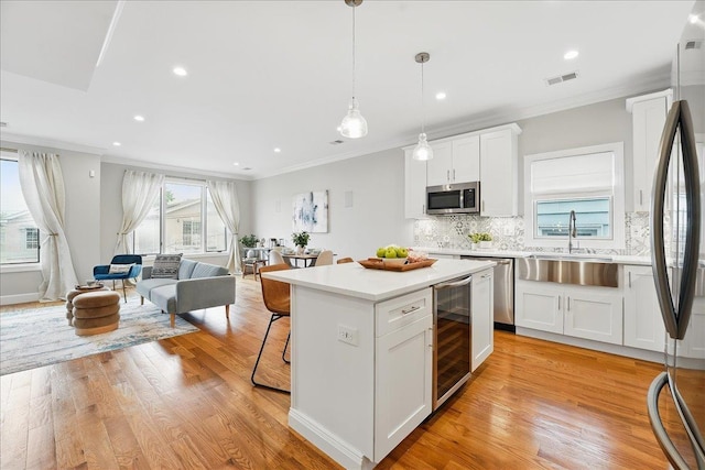 41 Graham St Unit 2, Jersey City, NJ 07307 - kitchen featuring wine cooler, a sink, stainless steel appliances, ornamental molding, and white cabinets