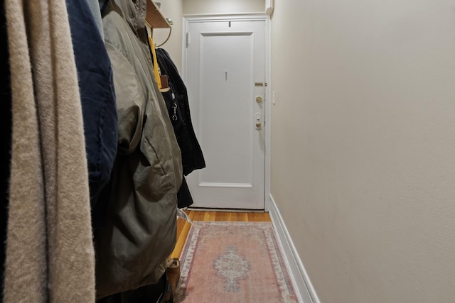 doorway to outside with baseboards and wood finished floors