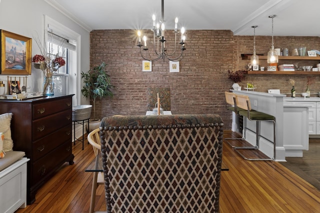 dining room featuring ornamental molding, an inviting chandelier, brick wall, and dark wood-style floors